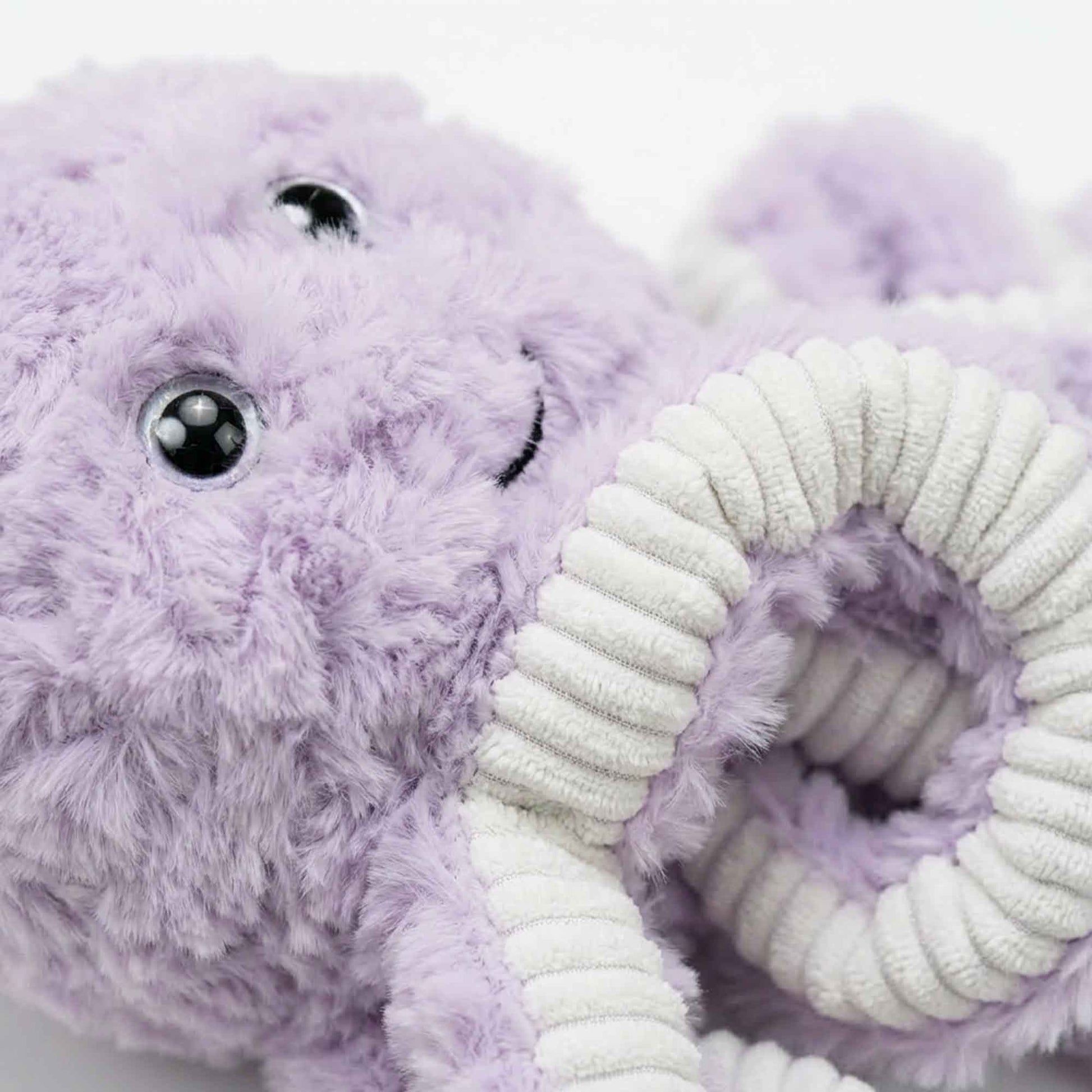 Close-up of squeaky octopus plush dog toy showing soft faux rabbit fur, ribbed tentacles for gentle plaque removal and gum massage, and cute smiling face