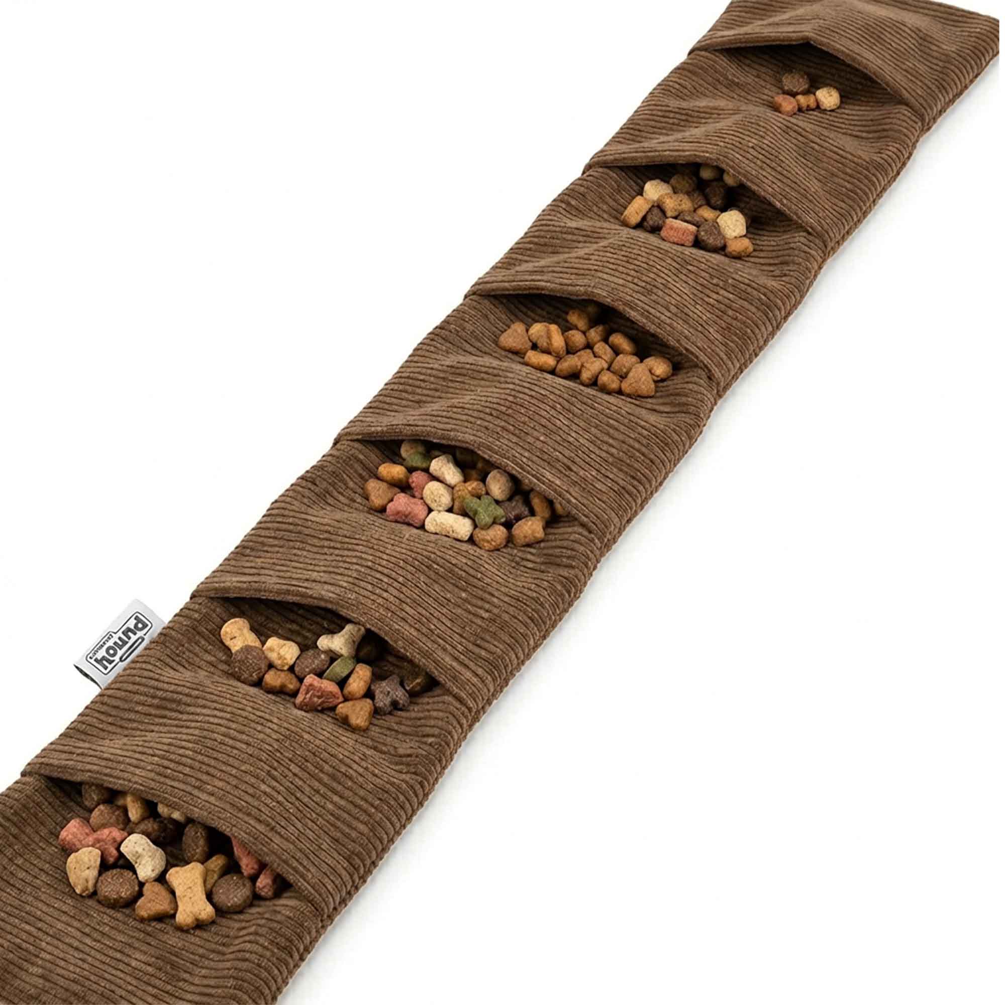 Close-up of brown corduroy snail dog toy showing multiple treat pockets stuffed with kibble – perfect for mental stimulation and foraging fun